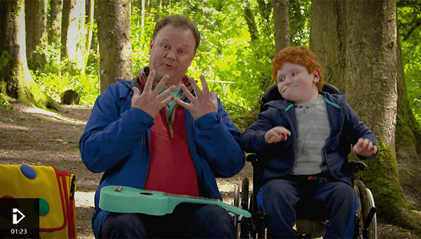 Justin Fletcher signing with a young boy