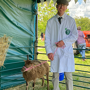 A man standing next to a sheep