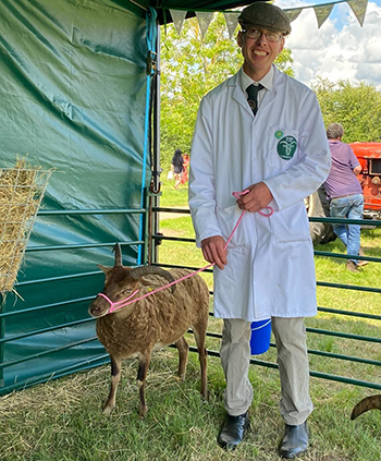 A man standing next to a sheep