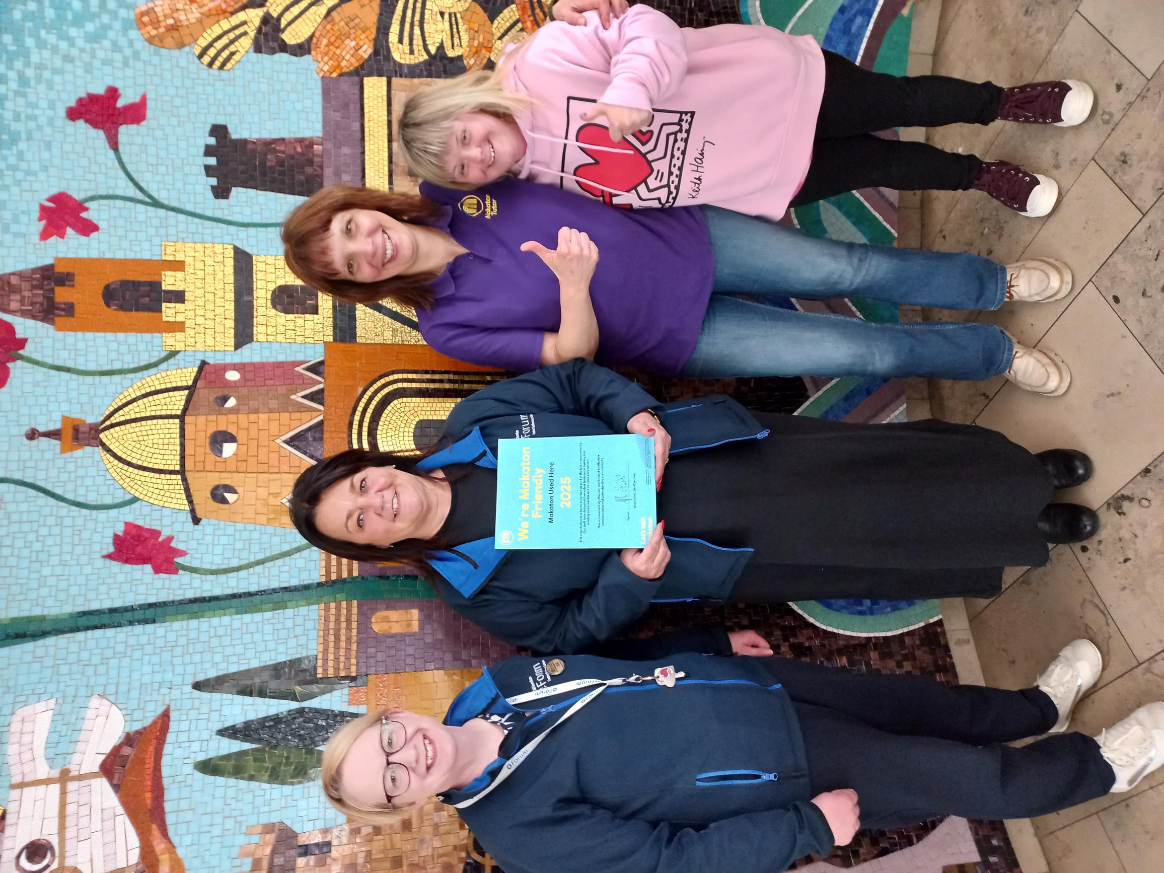 Ana and Maria, with staff from the Millennium Forum holding their Makaton Friendly certificate